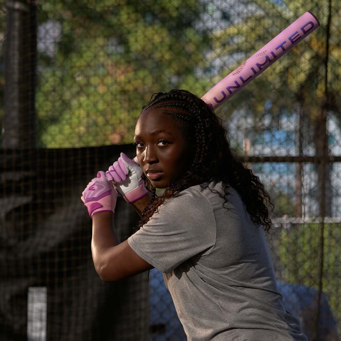 2026 Easton Ghost Unlimited Fastpitch Softball Bat held by a softball player in front of a backstop